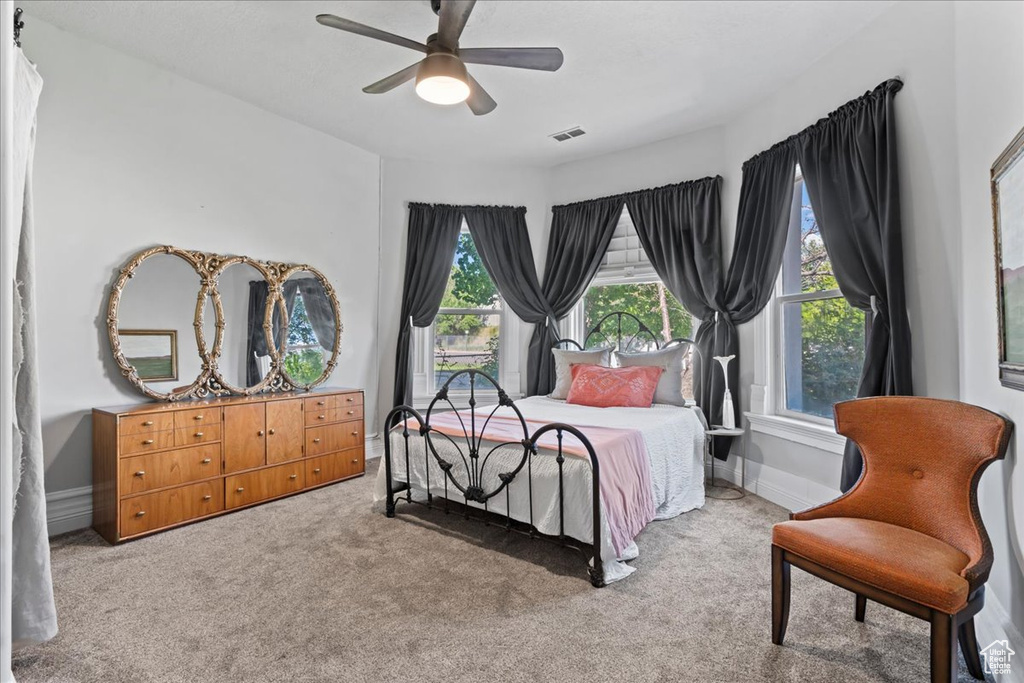 Carpeted bedroom with ceiling fan and baseboards