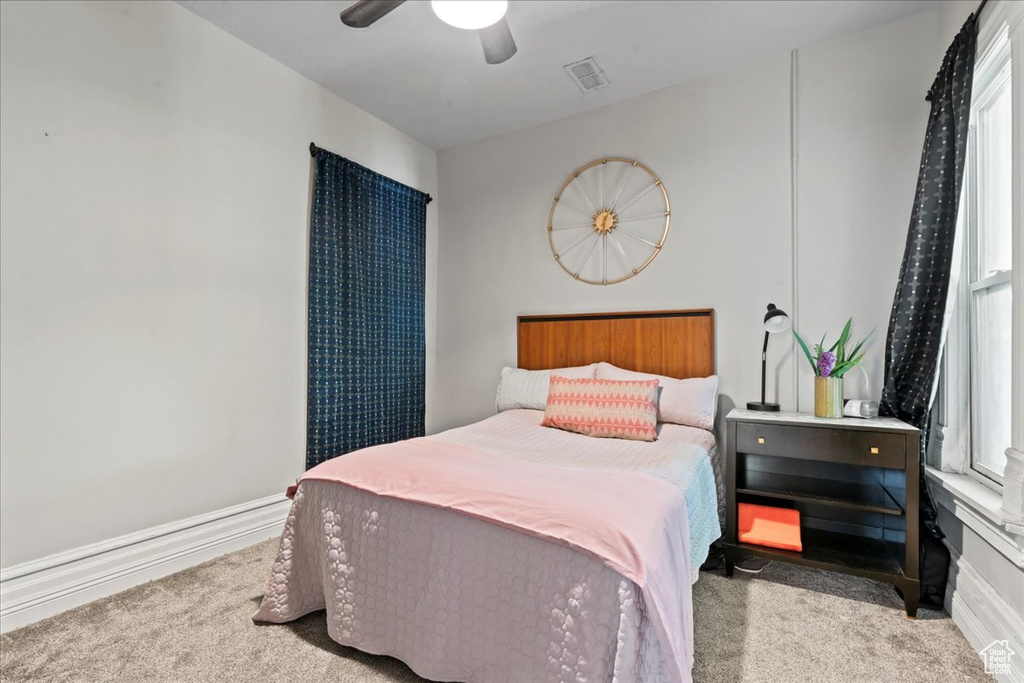 Carpeted bedroom with a ceiling fan