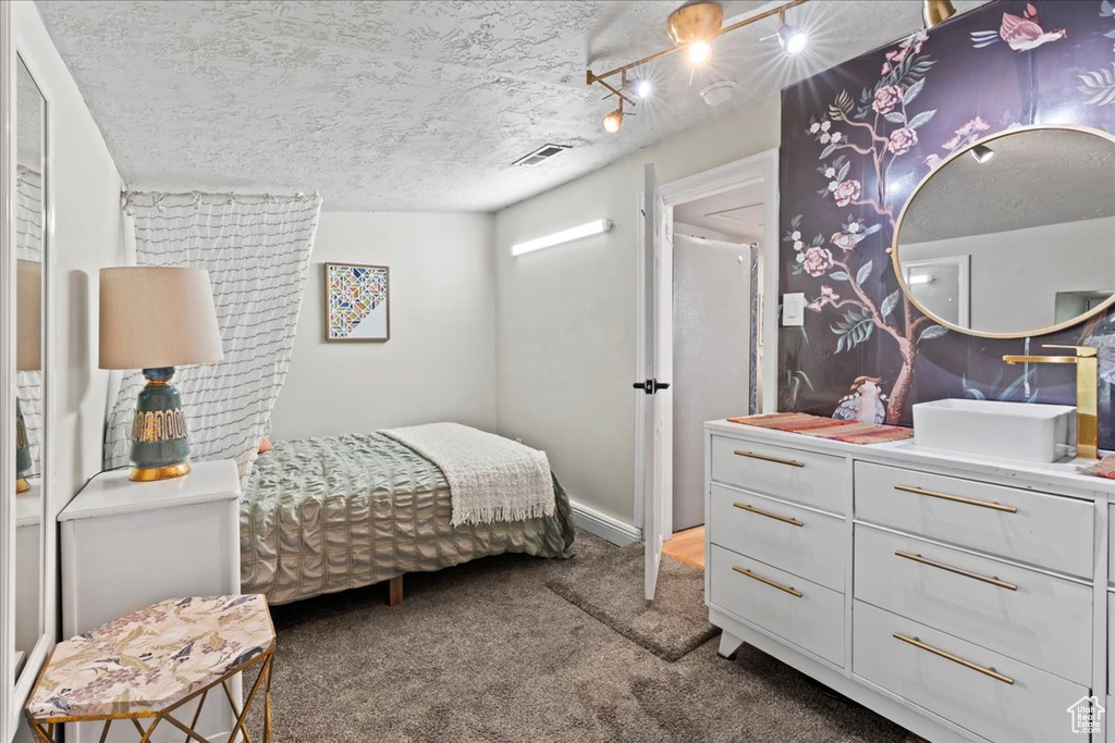 Bedroom featuring carpet flooring and a textured ceiling