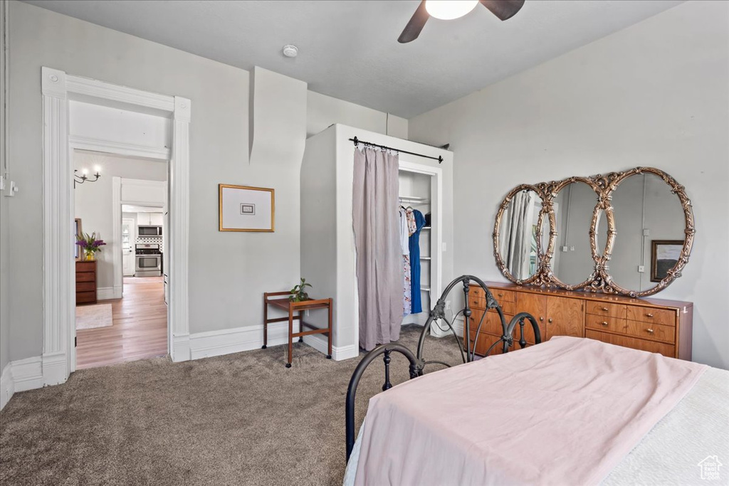 Carpeted bedroom with a closet, a ceiling fan, and baseboards