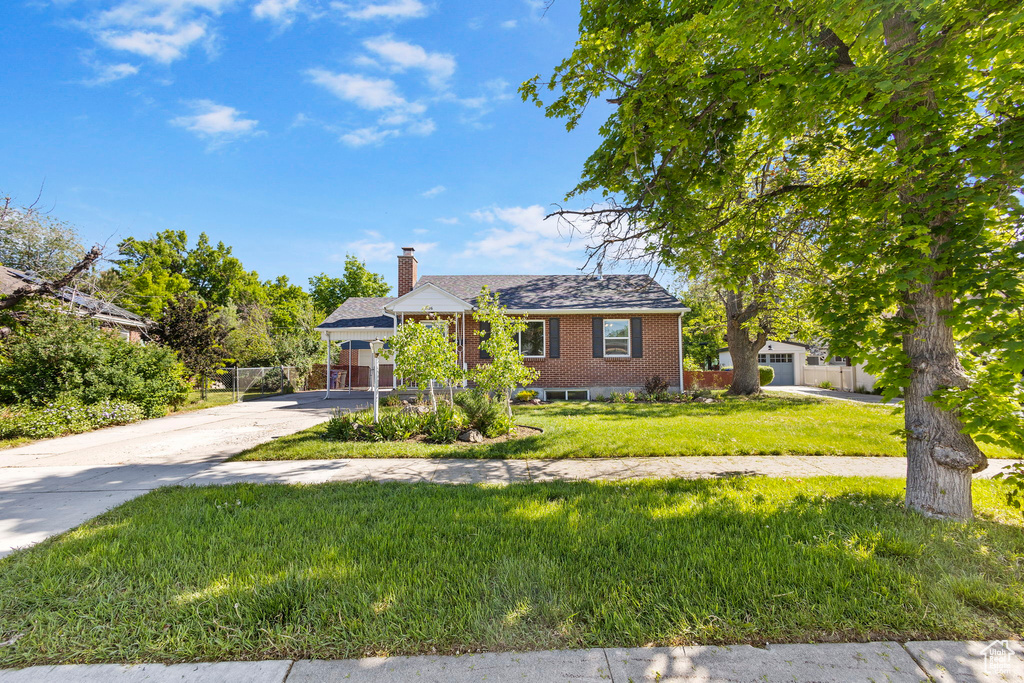 View of front of property featuring brick siding, a chimney, and driveway