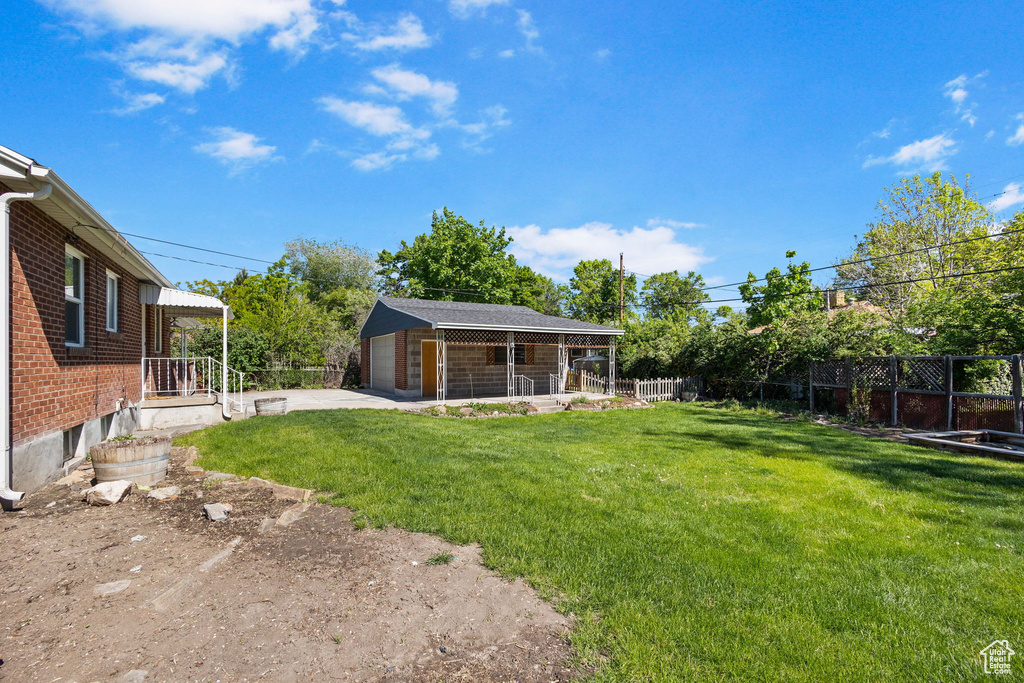 View of yard with a detached garage and an outbuilding