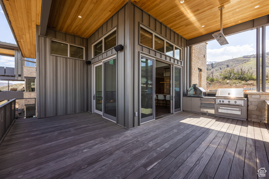 Wooden terrace with exterior kitchen, area for grilling, and a mountain view