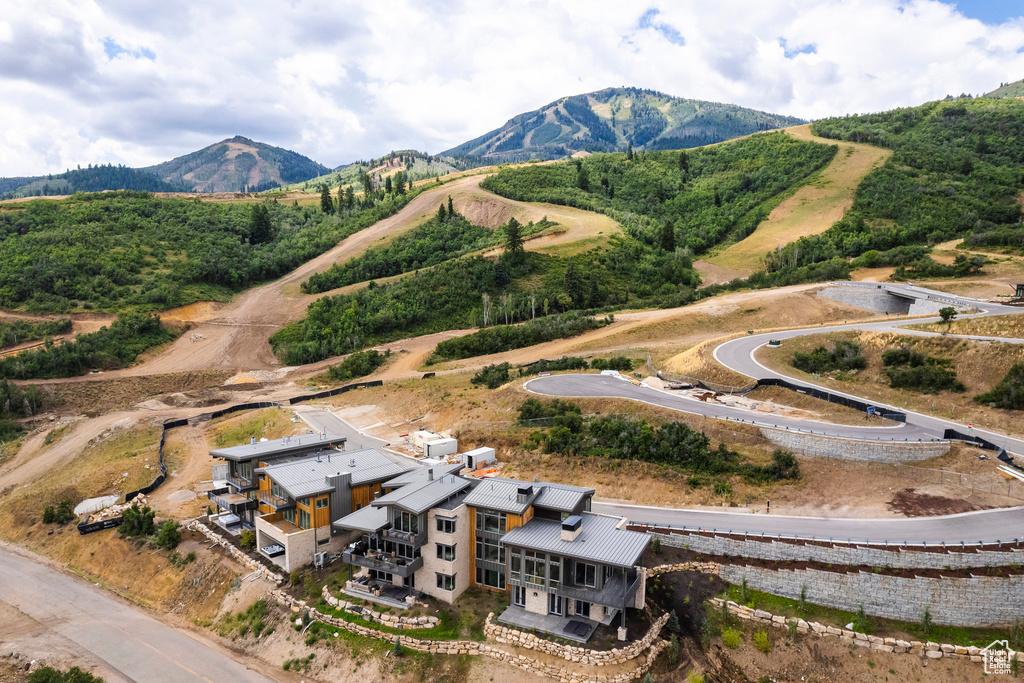 Aerial view of property and surrounding area featuring a mountainous background