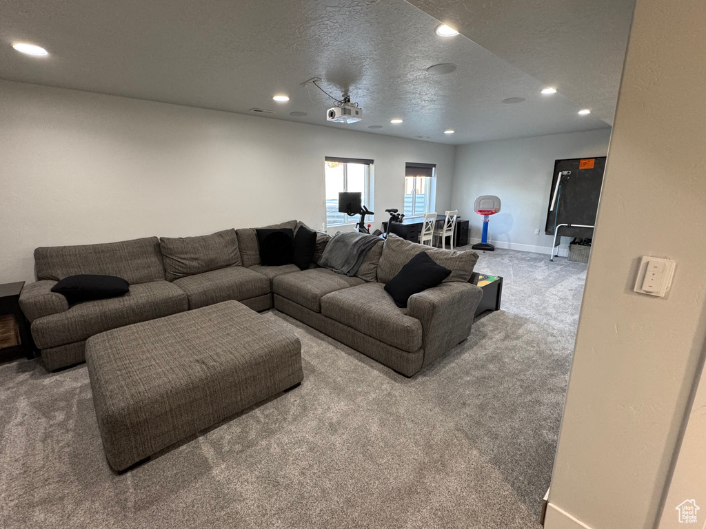Carpeted living area featuring recessed lighting, baseboards, and a textured ceiling