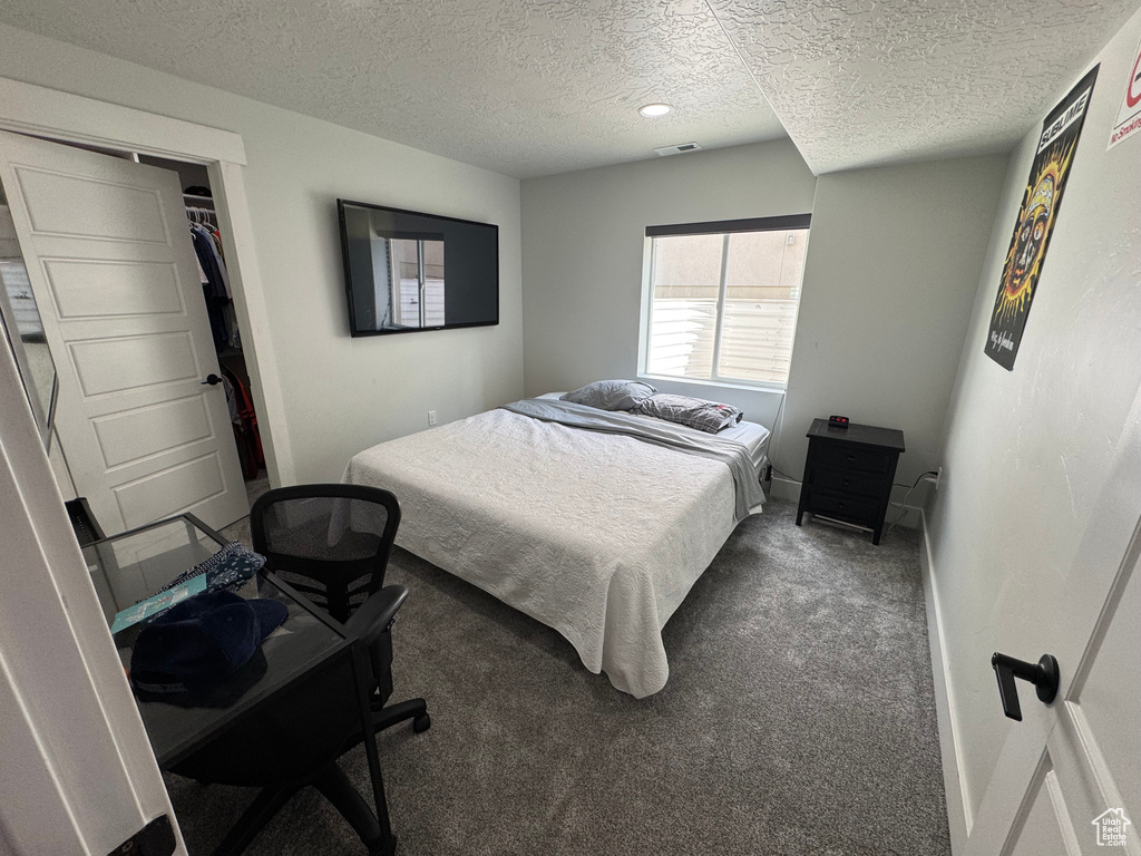 Bedroom featuring a textured ceiling, carpet, and baseboards