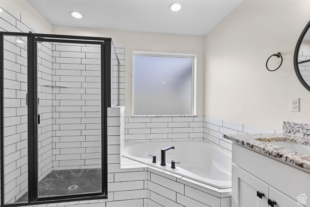 Full bath featuring a stall shower, a garden tub, recessed lighting, and vanity