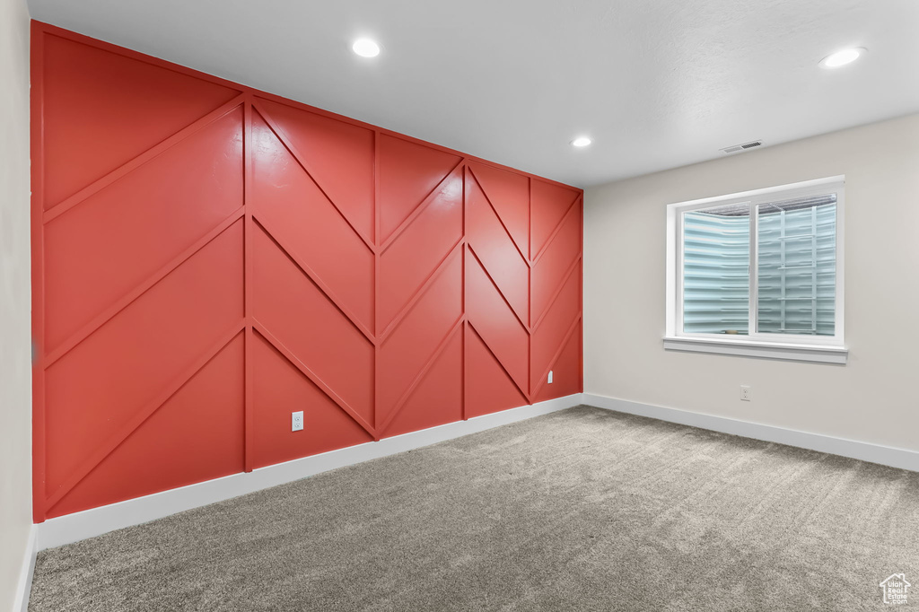 Unfurnished room featuring baseboards, carpet, recessed lighting, and a decorative wall
