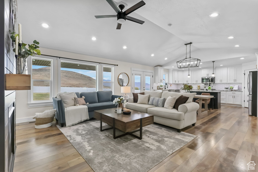 Living room with vaulted ceiling, ceiling fan, light wood-type flooring, and recessed lighting