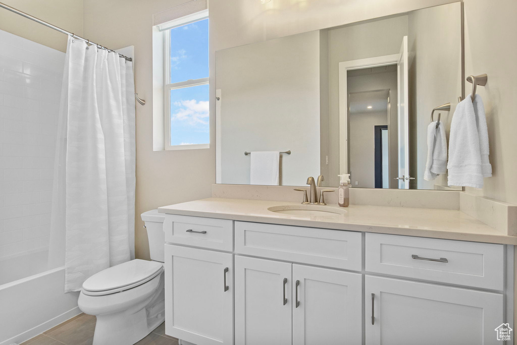 Full bath featuring toilet, vanity, and shower / bath combo