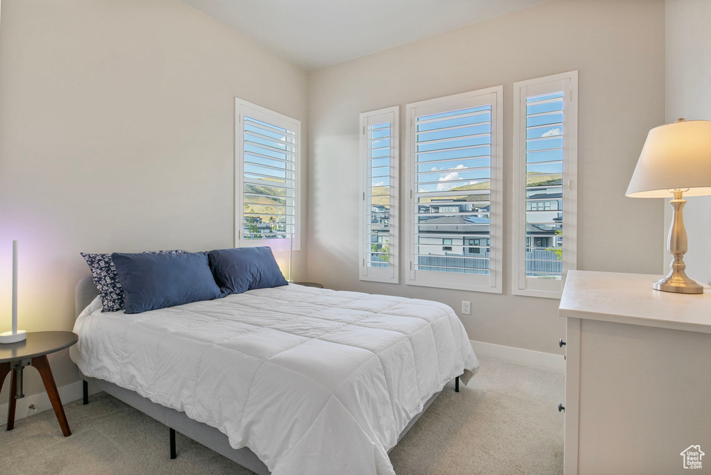 Bedroom featuring light colored carpet and baseboards