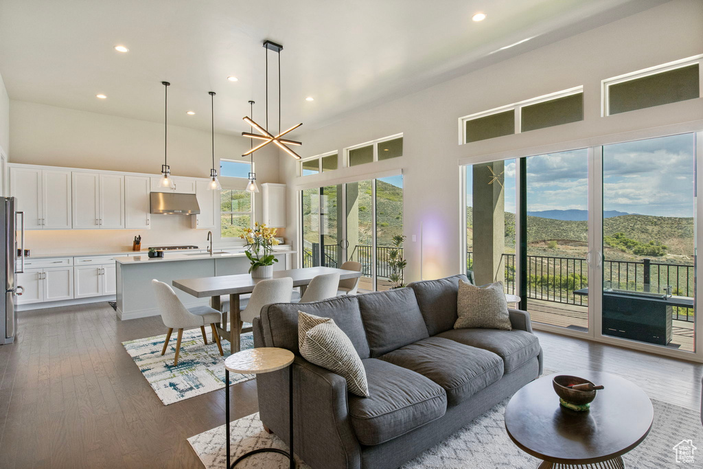 Living area featuring a towering ceiling, recessed lighting, dark wood finished floors, and a mountain view