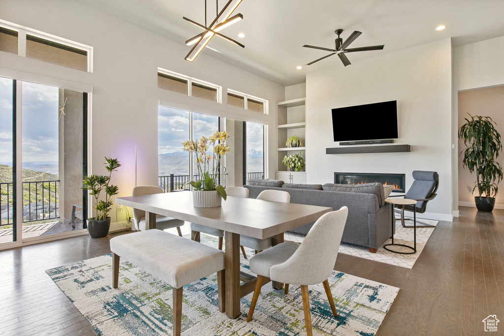 Dining room with healthy amount of natural light, a glass covered fireplace, built in features, recessed lighting, and dark wood finished floors