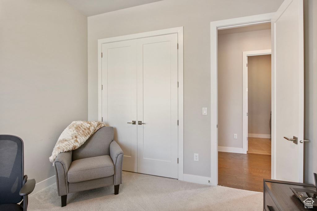 Living area featuring baseboards and light carpet