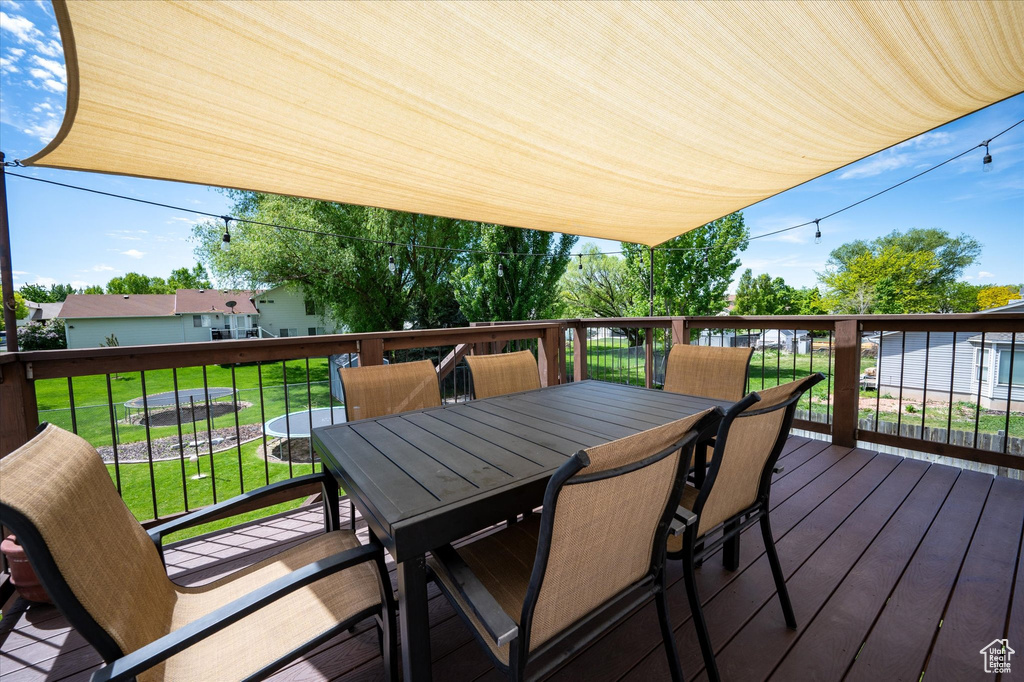 Wooden terrace featuring a yard and outdoor dining space