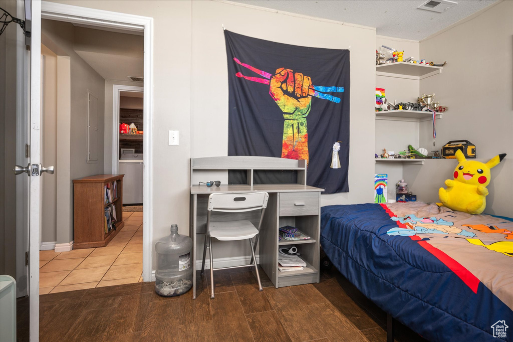 Bedroom with wood finished floors and washer / dryer