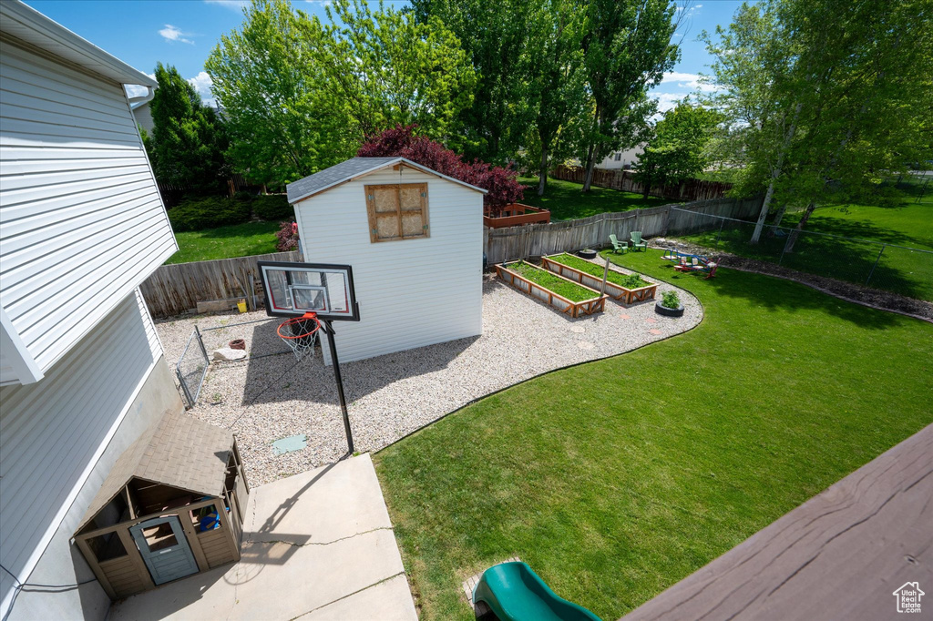 View of yard featuring a garden, an outbuilding, a patio area, and a shed