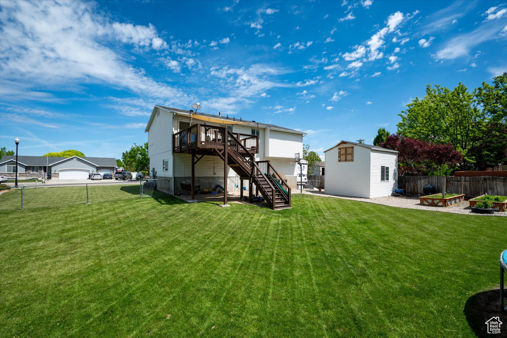 Rear view of house with stairs, a deck, and an outbuilding