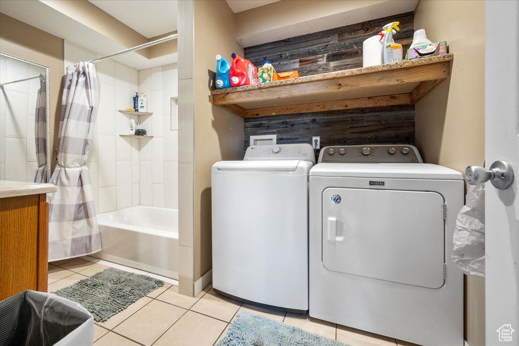 Laundry area with washer and clothes dryer and light tile patterned floors