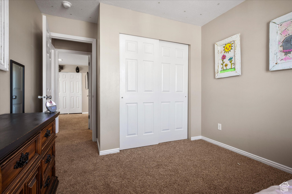 Carpeted bedroom featuring baseboards and a closet