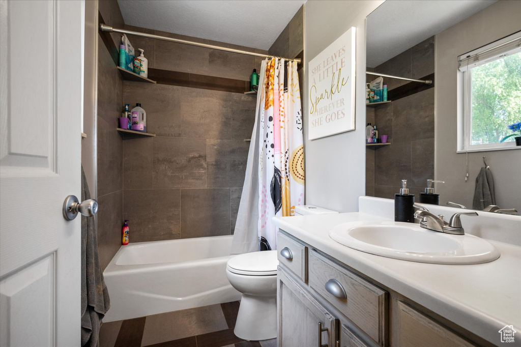 Bathroom with vanity, toilet, shower / bath combination with curtain, and wood finished floors