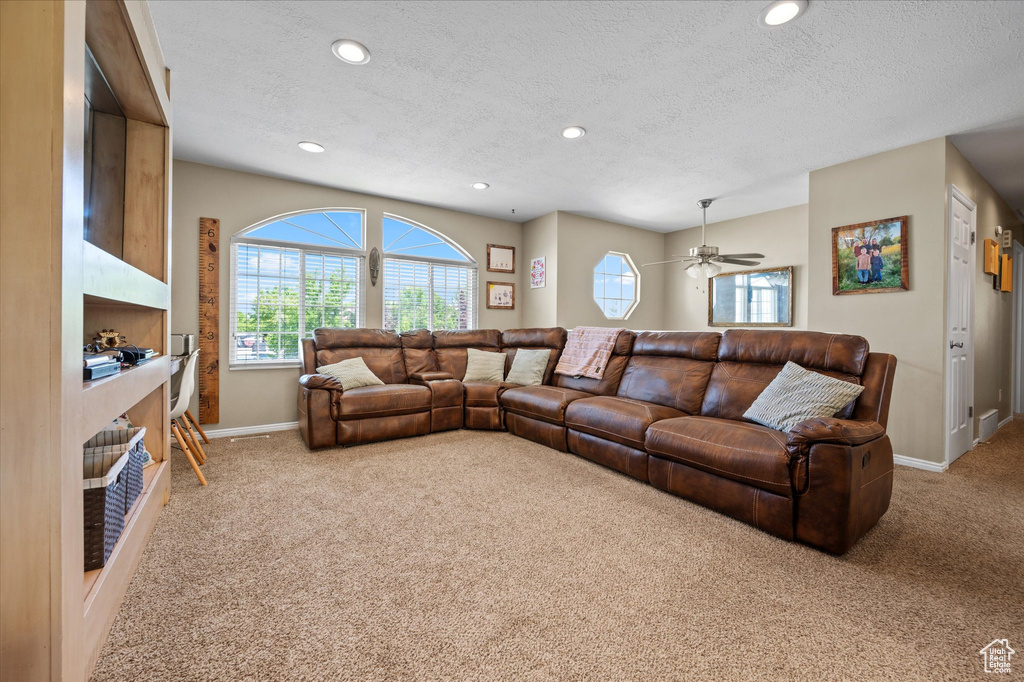 Living room featuring carpet, a textured ceiling, baseboards, recessed lighting, and a ceiling fan