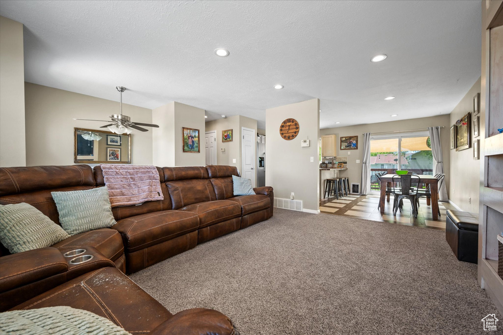 Living room featuring carpet flooring, a ceiling fan, recessed lighting, and baseboards