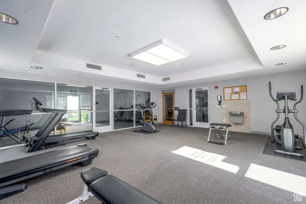 Gym with a tray ceiling and recessed lighting