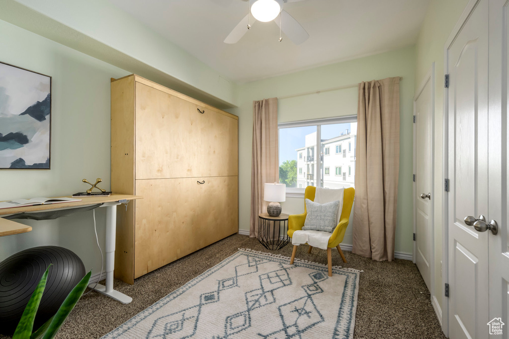 Living area with ceiling fan and baseboards