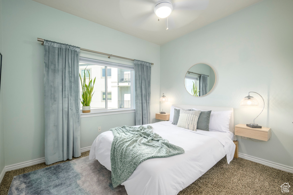 Carpeted bedroom with baseboards and a ceiling fan