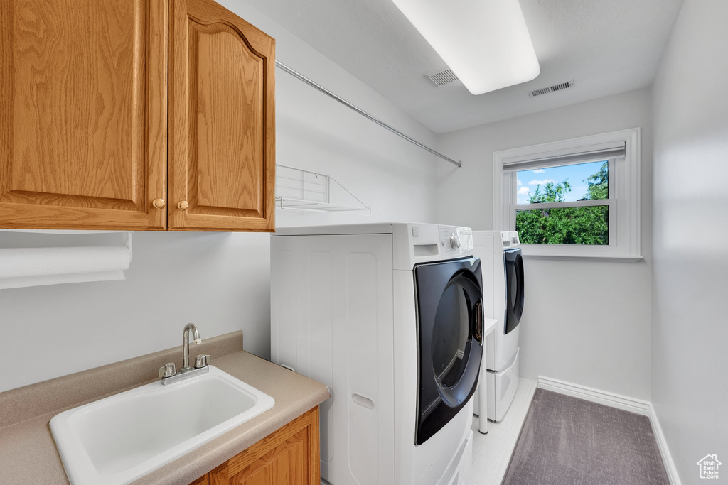 Laundry area with cabinet space, washer and dryer, and baseboards