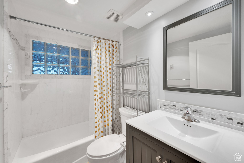 Bathroom with toilet, vanity, backsplash, shower / bathtub combination with curtain, and recessed lighting