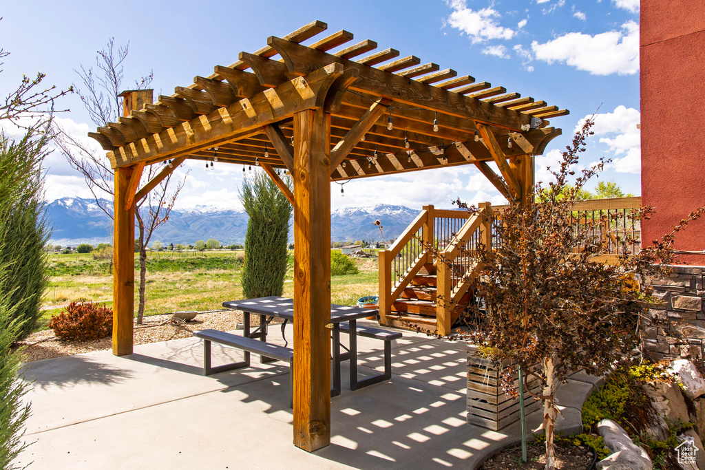 View of patio / terrace with a pergola, a mountain view, and stairs