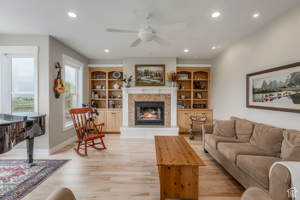 Living area featuring recessed lighting, light wood-style floors, a fireplace, a ceiling fan, and baseboards