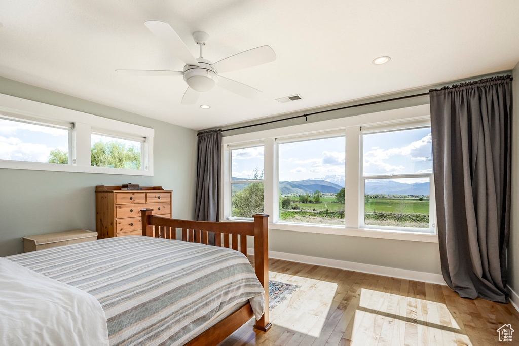 Bedroom with light wood-style floors, baseboards, a mountain view, recessed lighting, and ceiling fan