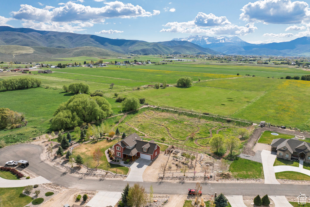 Aerial view of property and surrounding area with rural landscape, a mountain backdrop, and agricultural land