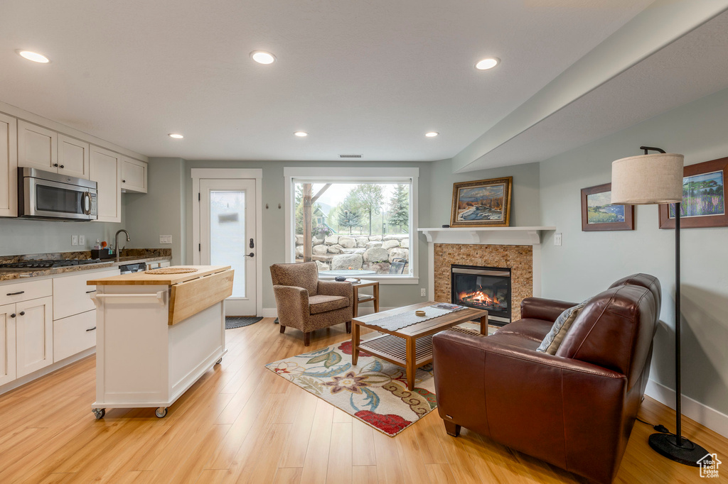 Living area with a fireplace, light wood-style floors, recessed lighting, and baseboards