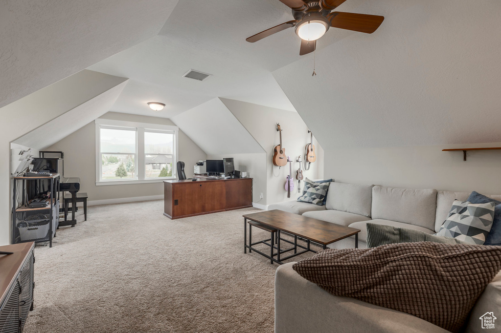 Living room with an office area, light colored carpet, vaulted ceiling, a ceiling fan, and baseboards