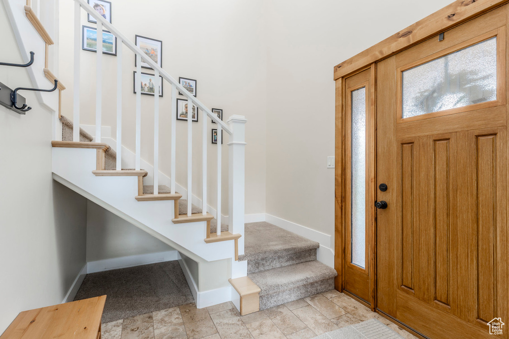 Entrance foyer with stairway and baseboards