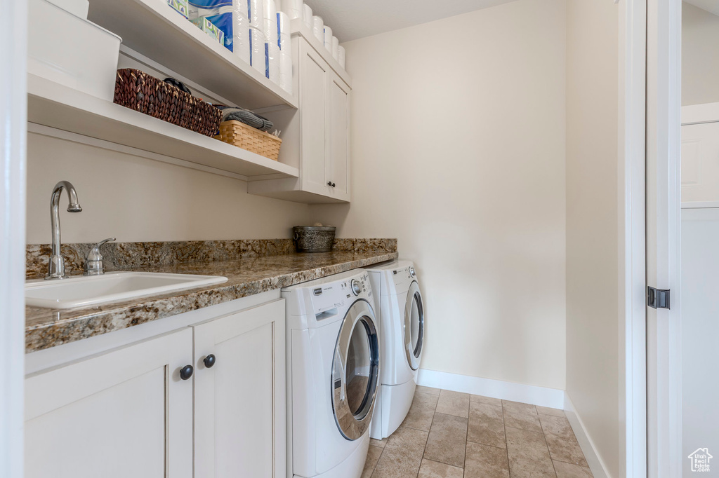 Laundry area with cabinet space, washing machine and clothes dryer, and baseboards