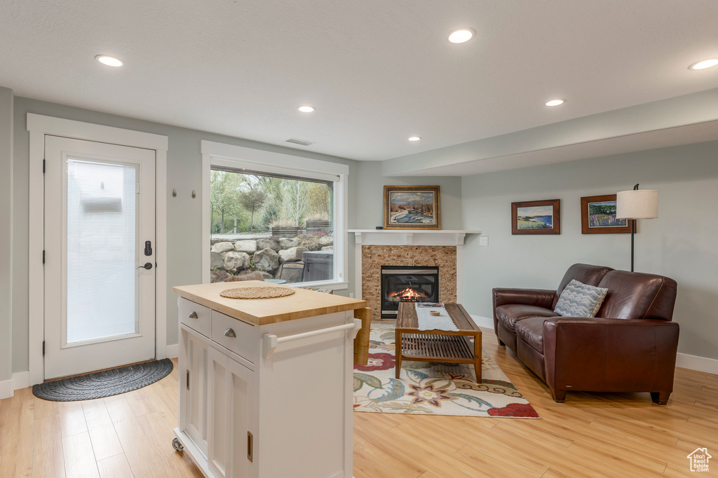 Living area featuring light wood-style floors, a fireplace, recessed lighting, and baseboards