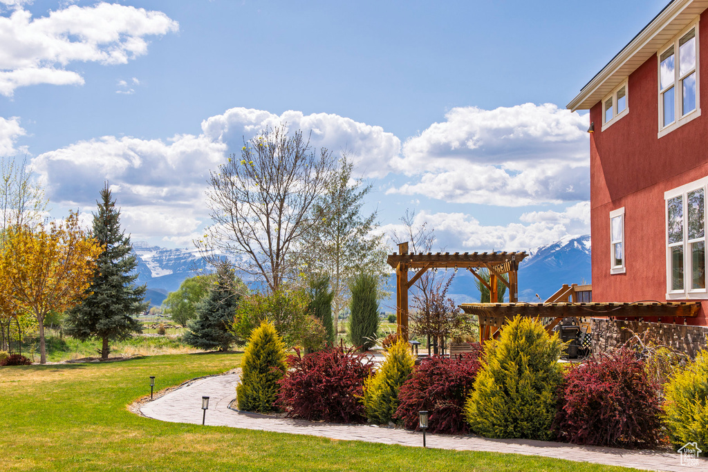 View of home's community featuring a pergola and a lawn