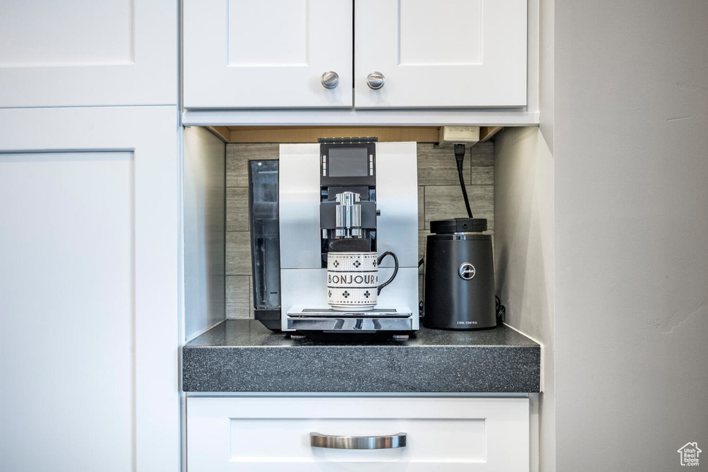 Kitchen view of white cabinets, dark countertops, and decorative backsplash