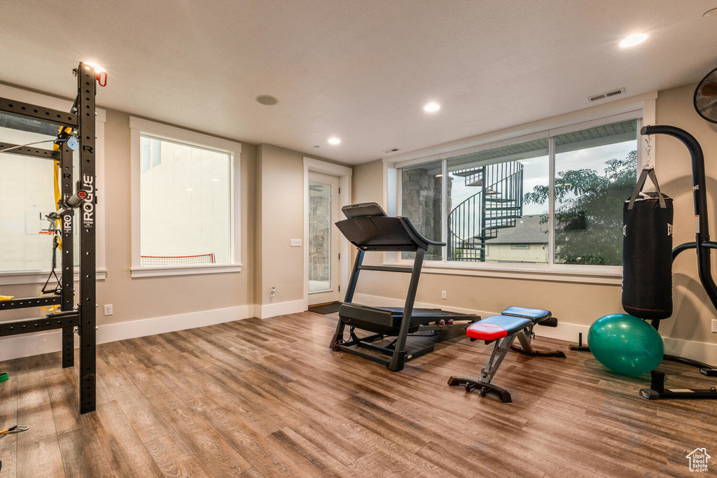 Workout area featuring wood finished floors, baseboards, and recessed lighting