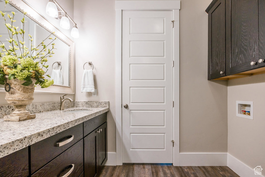 Bathroom featuring wood finished floors, vanity, and baseboards