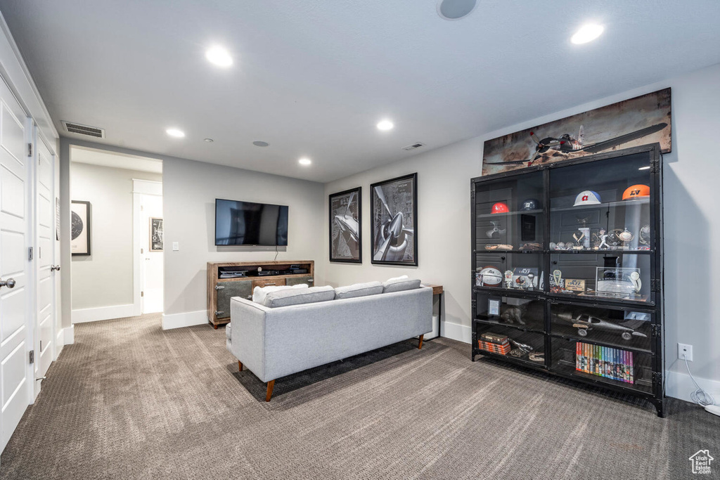 Carpeted living room with recessed lighting and baseboards