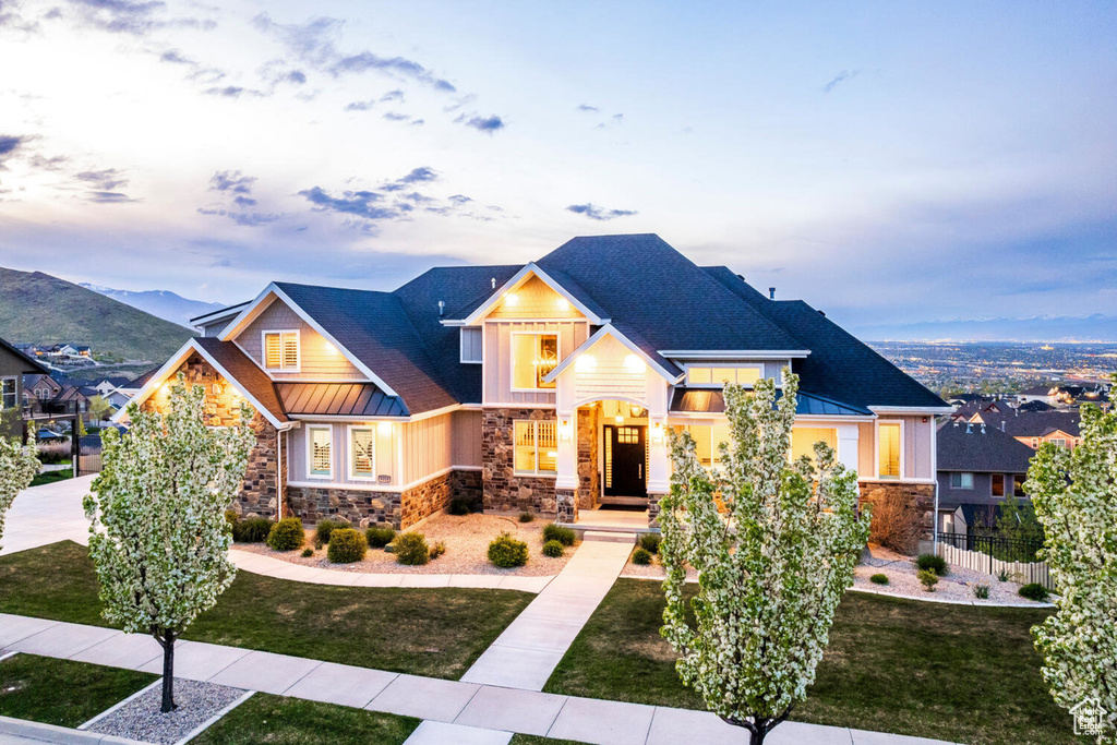 Craftsman house featuring stone siding, a standing seam roof, board and batten siding, and metal roof