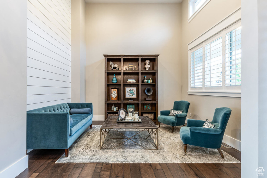 Sitting room with wood finished floors, baseboards, and a towering ceiling