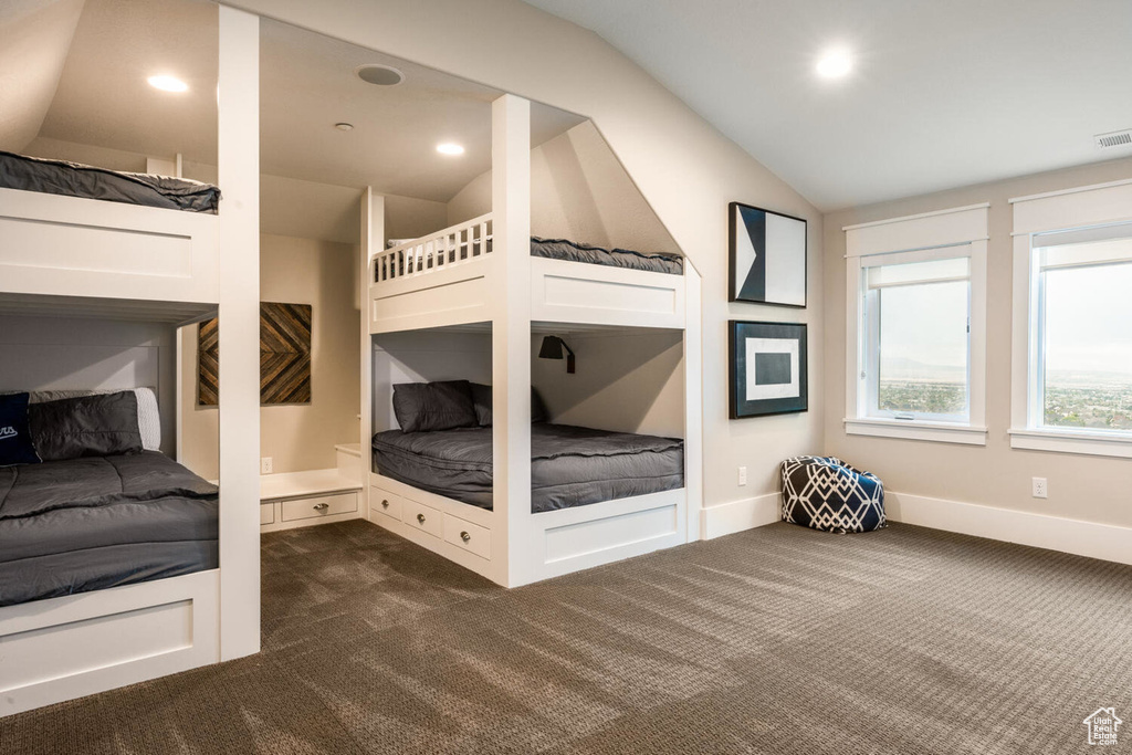 Unfurnished bedroom with dark colored carpet, vaulted ceiling, recessed lighting, and baseboards