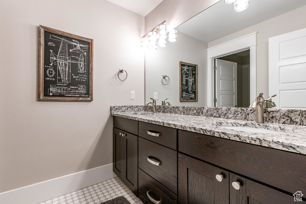 Full bathroom featuring double vanity and baseboards